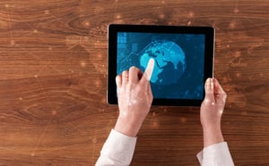 Hand touching tablet with worldwide reports links and statistics concept