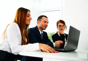 Happy businesspeople working on the laptop together